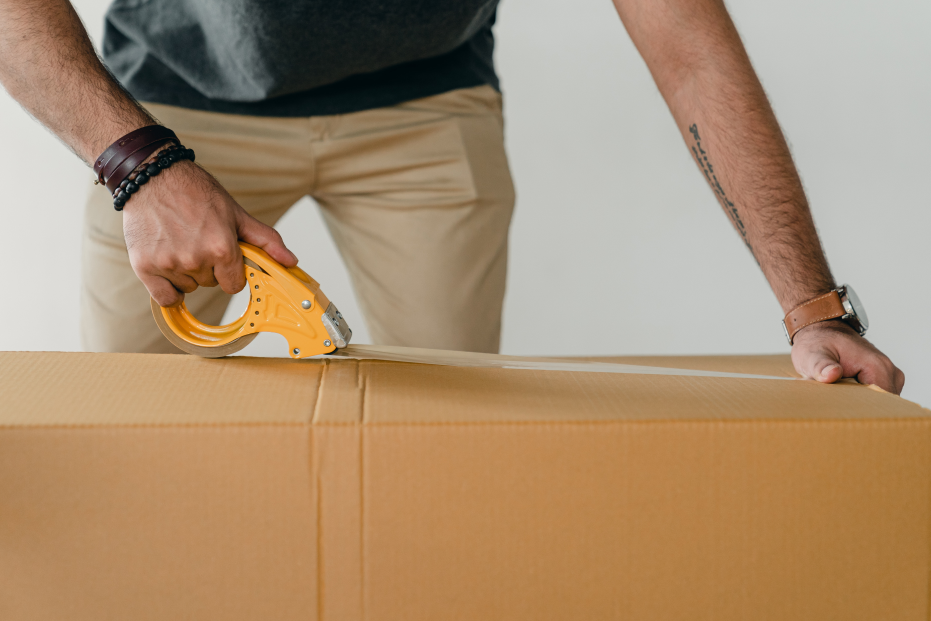 Image of a man's arm taping up a box ready for storage in an Ez Self Storage container